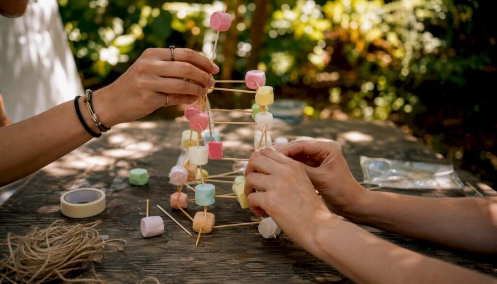 Hands building marshmallow tower