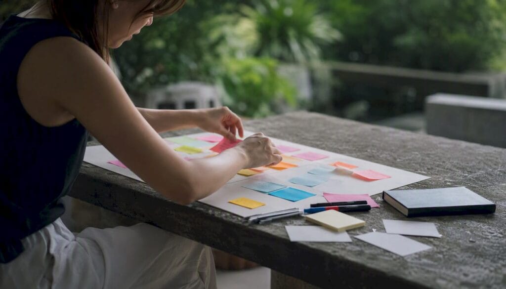 Hands arranging sticky notes in brainstorming session