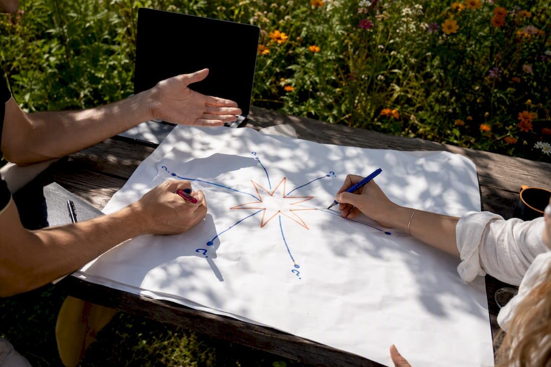 Hands creating starburst brainstorming diagram