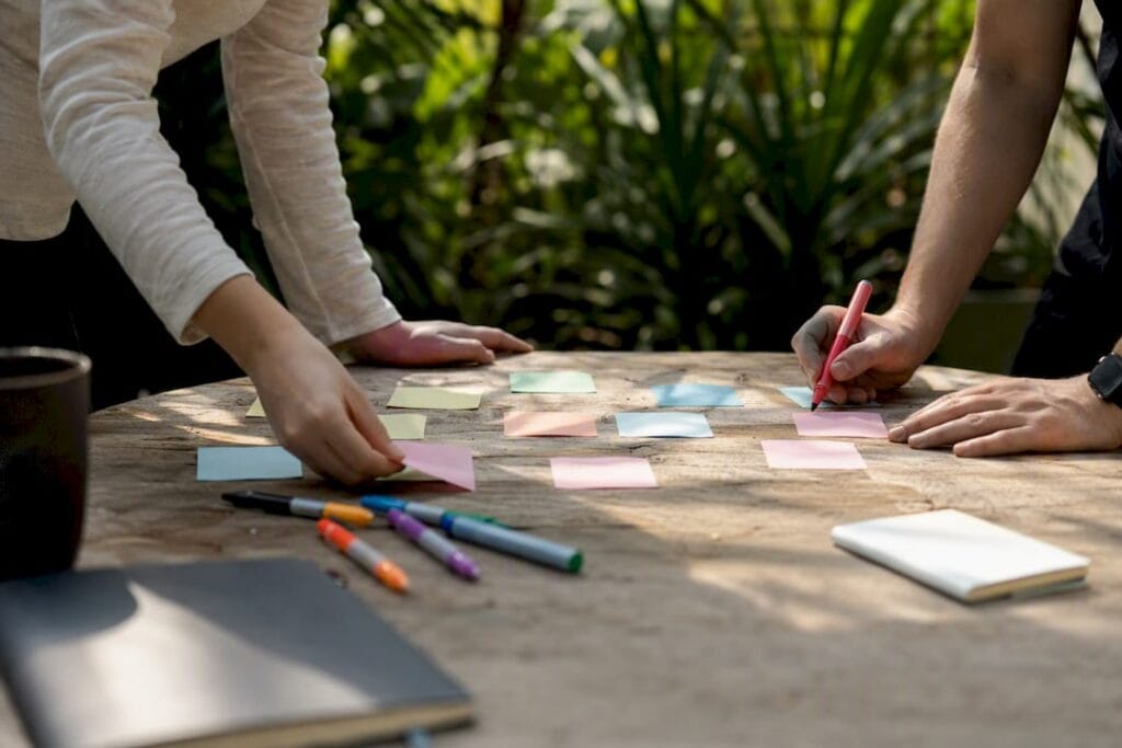 Hands arranging brainstorming sticky notes